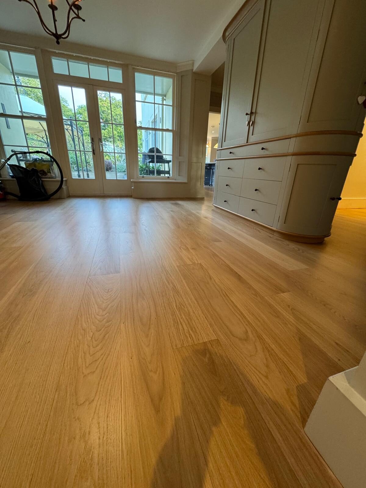Engineered oak wide-plank flooring in a period bay-window room